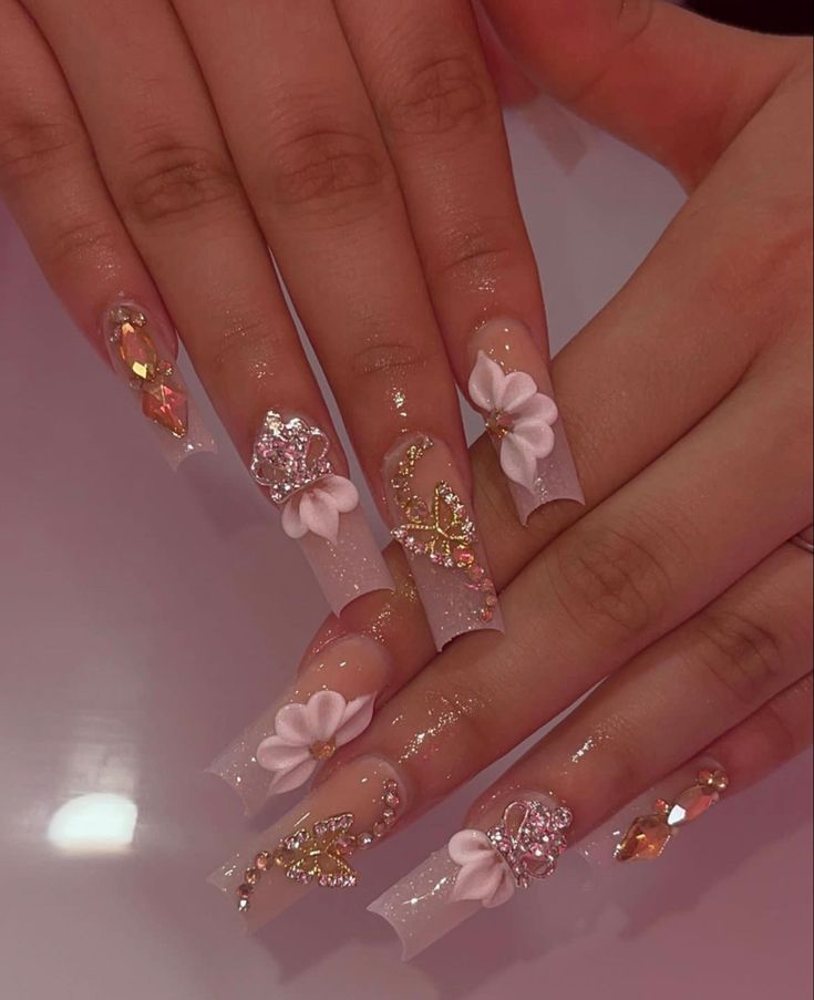 Elegantly Glamorous Floral-Embellished Nail Design with Elongated Tips and Sparkling Accents.