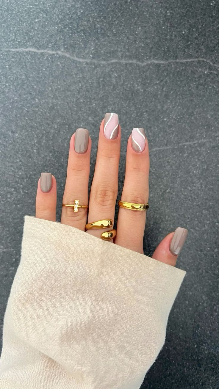 Chic Neutral Nail Design with Glossy Accents and Delicate Gold Rings