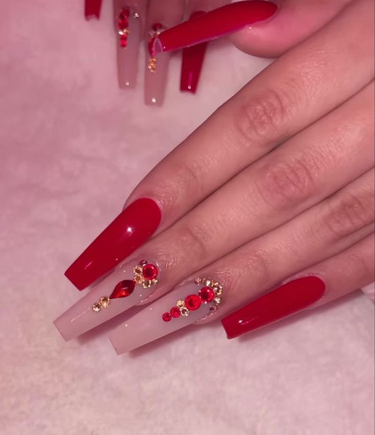 Luxurious Stiletto Nail Design: Bold Red and Soft Nude with Gem and Gold Embellishments.