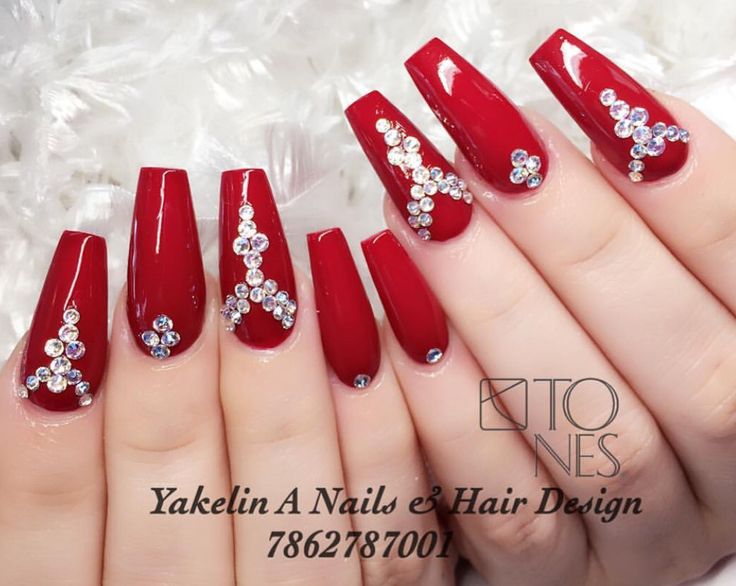 Chic Red Nail Design: Striking Elongated Nails Adorned with Shimmering Rhinestones for a Glamorous Look.