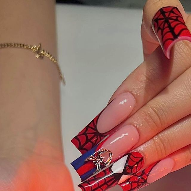 Vibrant Red and Black Spider-Themed Nail Design with Intricate Patterns and Decorative Charm.