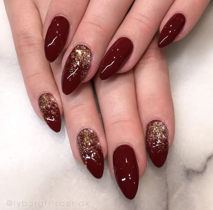 Sophisticated Almond-Shaped Nails with Deep Burgundy Polish and Gold Glitter Accent.