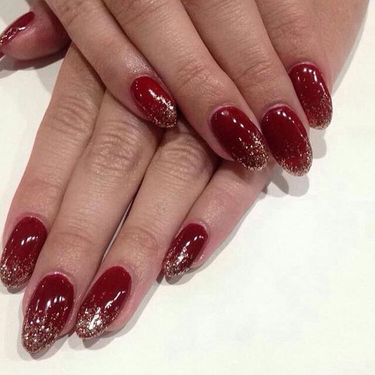 Elegant Red Ombre Nails with Glamorous Gold Glitter Tips for a Sophisticated Look.