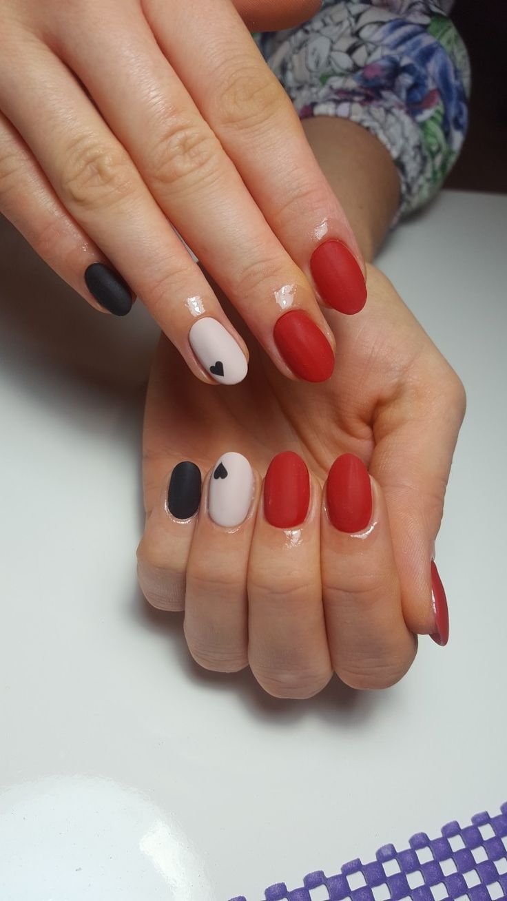 Chic Nail Design: Creamy Nude with Black Hearts and Vibrant Red Accents