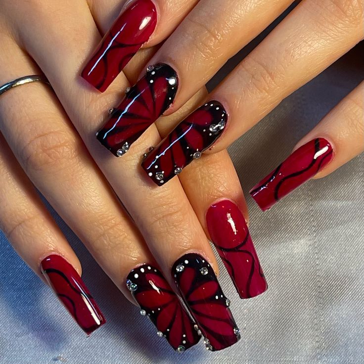 Striking Elegant Red and Black Floral Nail Design with Glossy Finishes and Rhinestones