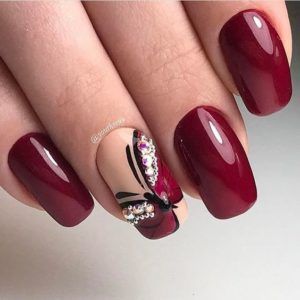 Sophisticated Burgundy Manicure with Glossy and Matte Finishes, Floral Designs, and Sparkling Rhinestones.