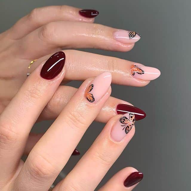 Whimsical Nail Design: Deep Burgundy and Soft Nude with Butterfly Motifs