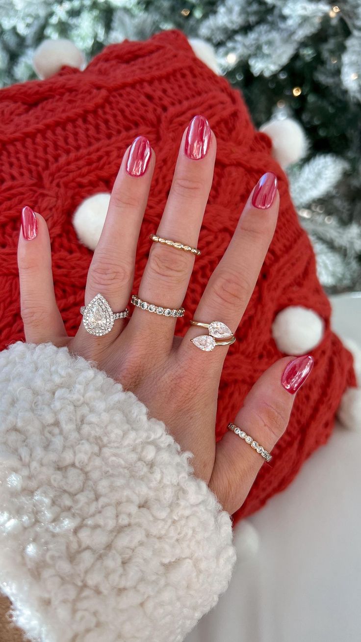 Glamorous Deep Red Manicure Accentuated by Delicate Rings Amidst a Cozy Festive Backdrop.