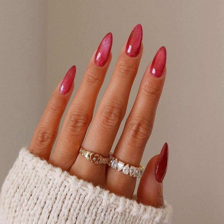 Elegant Almond-Shaped Nails with Shimmering Rosy Red Polish and Dazzling Accessories.