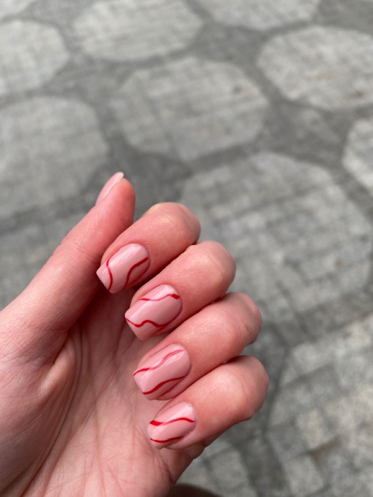 Elegant Soft Pink Nail Design with Striking Red Wavy Lines