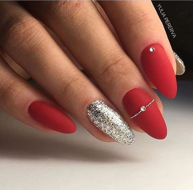 Sophisticated Red Matte Nails with Glitter Accent and Silver Embellishments for Chic Elegance.