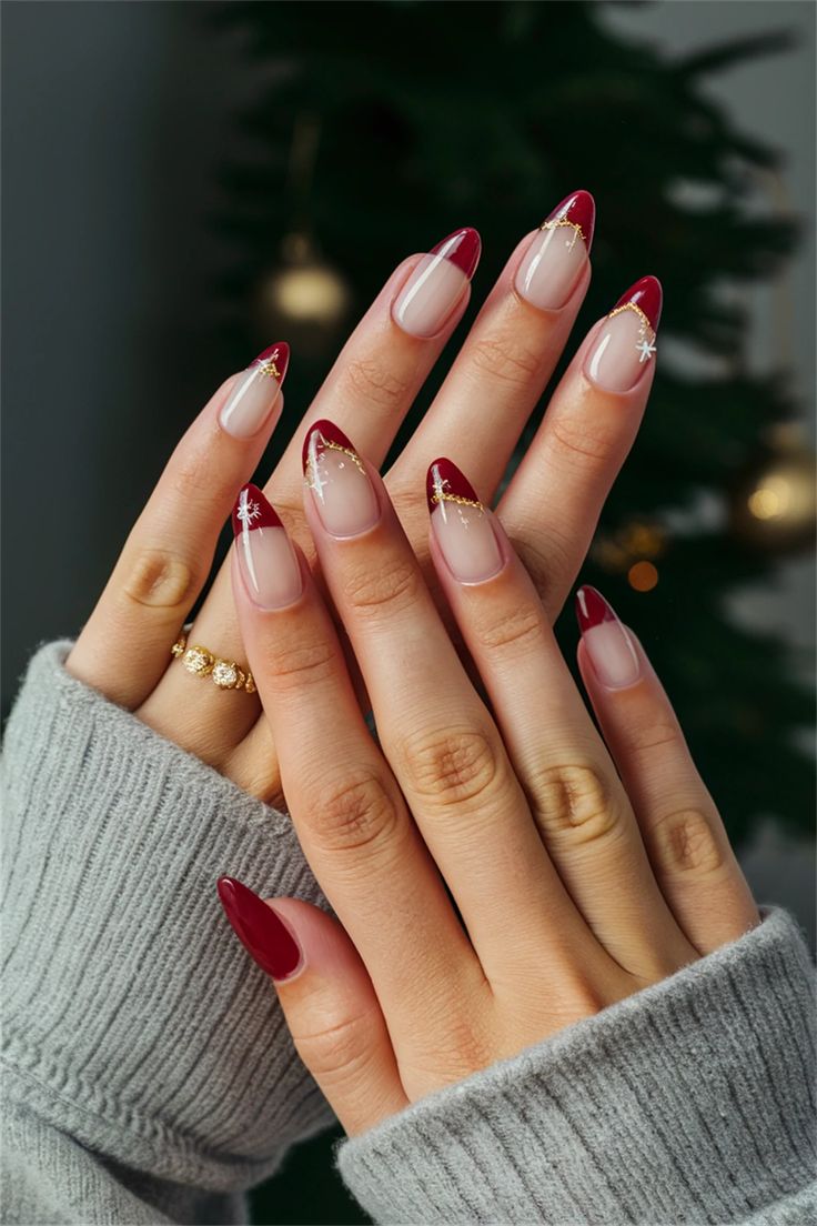 Chic Holiday Nail Design: Rich Crimson Tips on Subtle Nude Base with Golden Accents and Snowflakes