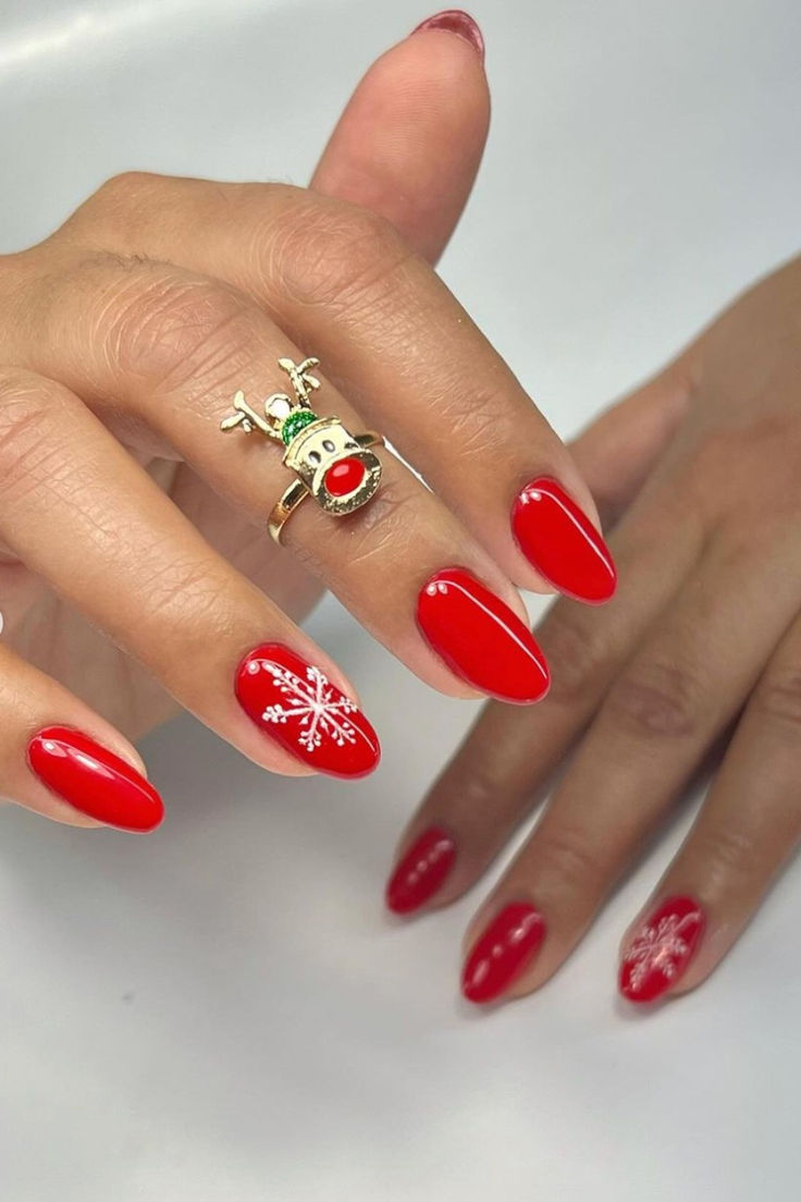 Charming Holiday Nails with Red Snowflakes and a Whimsical Reindeer Ring.