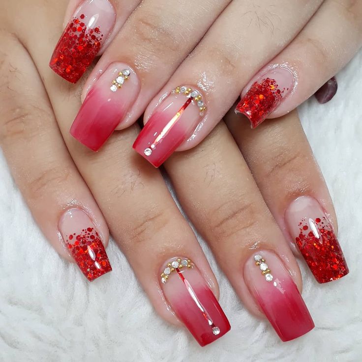 Glamorous Sparkling Red Ombre Nails with Glitter and Gem Accents.