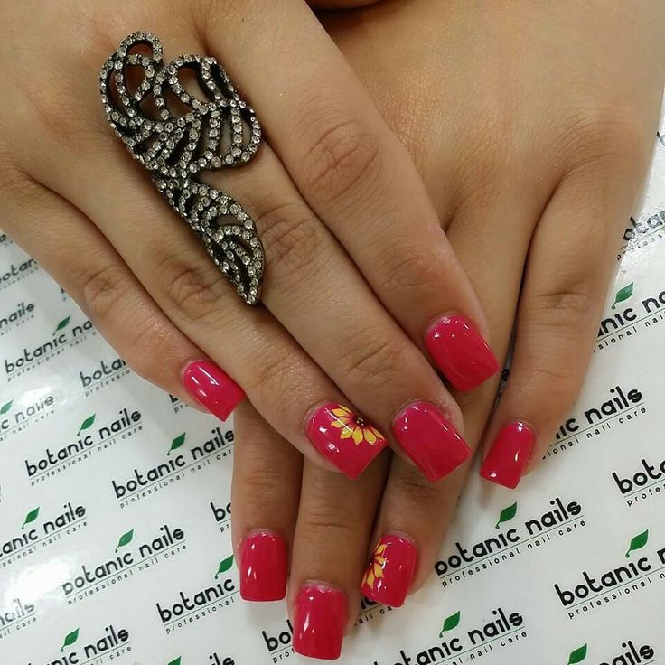 Chic Vibrant Pink Nail Design with Glossy Finish and Floral Accent, Complemented by an Elegant Statement Ring.