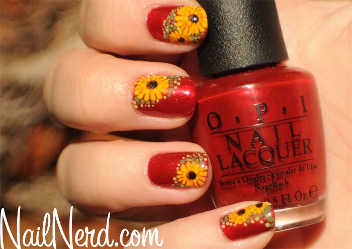 Vibrant Red Nail Design with Intricate Sunflower Patterns for a Cheerful Look.