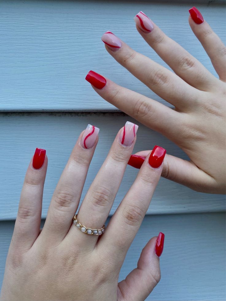 Chic Red and Pink Nail Design: Bold Colors with Elegant Swirls and Gold Accents.