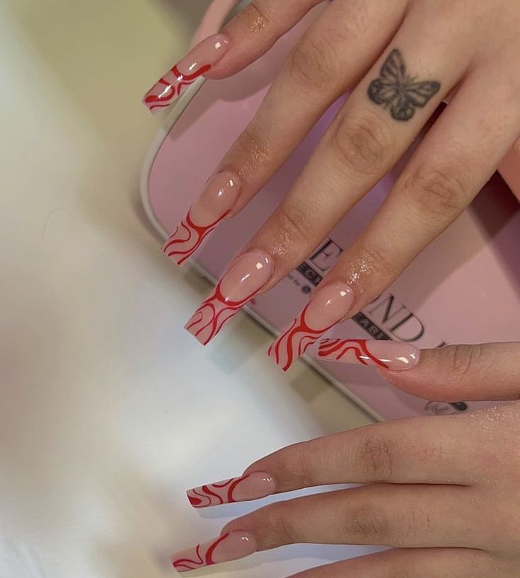 Chic Nude Acrylic Nails with Striking Red Wave Designs and Delicate Butterfly Tattoo.