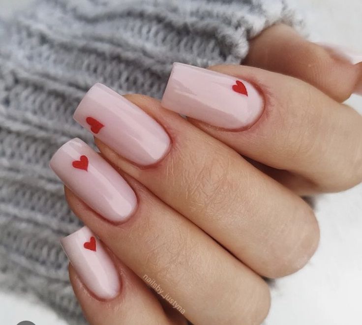 Charming Pastel Pink Nail Design with Heart Accents for a Whimsical Touch