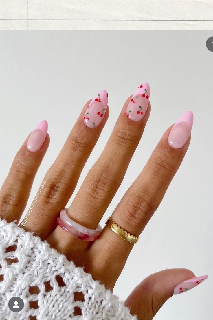 Chic Almond-Shaped Pink Nail Design with Playful Cherry Dots and Elegant Accessories.