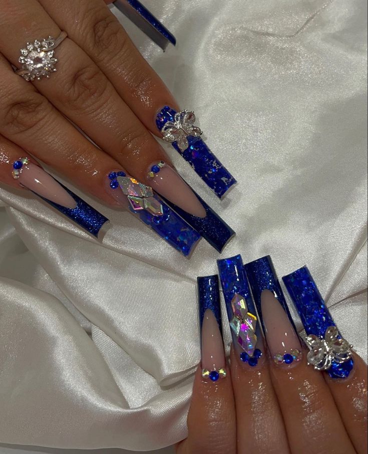 Elegant Blue-Inspired Nail Design with Intricate Embellishments and Glamorous Accents.