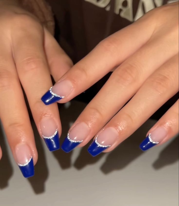 Chic Deep Blue French Tip Nail Design with Silver Embellishments.