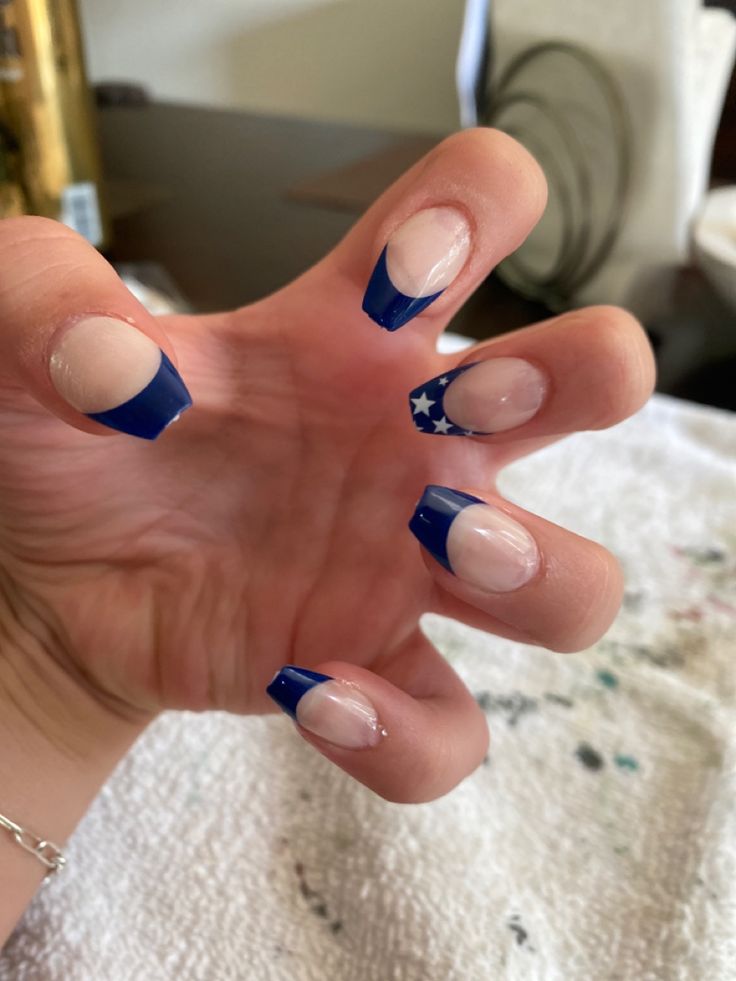 Bold Blue French Tip Nails with Unique Cutout and Star Accent.