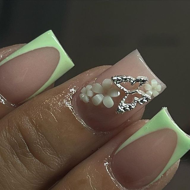 Chic Nude and Mint Nail Design with Floral Accents and Silver Butterfly Detail.