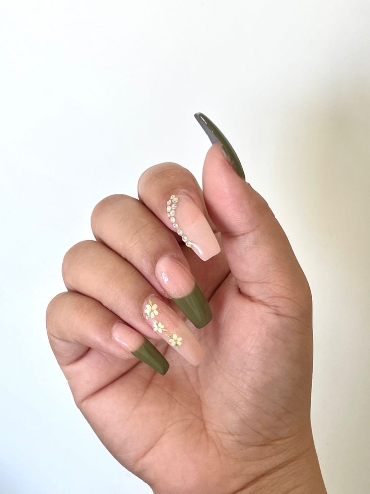 Elegant Almond Nail Design in Muted Green and Soft Nude with Floral Accents and Gem Embellishments