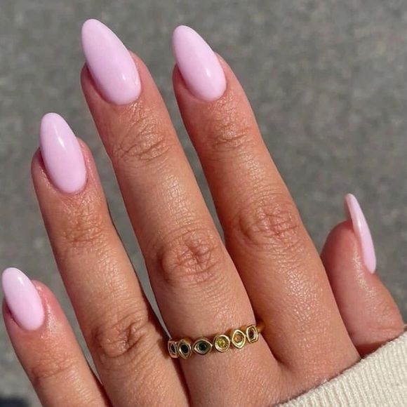 Chic Pastel Pink Almond Nails Enhanced by Glossy Finish and Accented with a Colorful Stone Gold Ring.