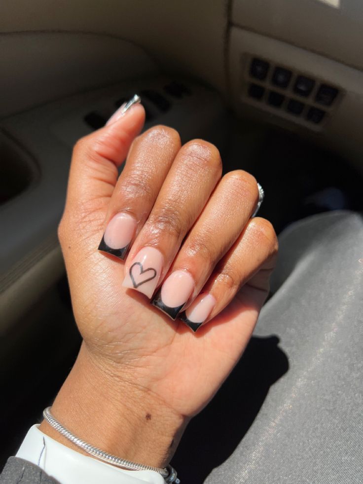 Chic Nude and Black Tipped Nail Design with Charming Heart Accents