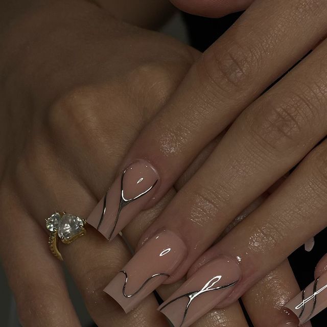 Chic Nude Nail Design with Glossy Finish and Sleek Silver Accents