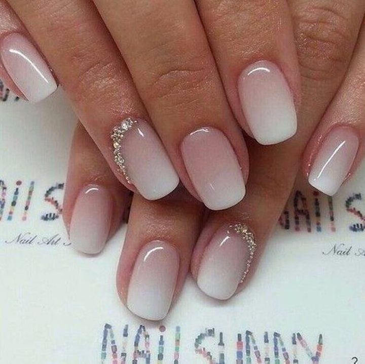 Elegant Ombre Nail Design: Soft White to Pale Pink Gradient with Subtle Cuticle Accents.