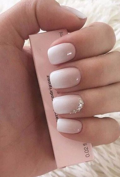 Chic Ombre Nail Design: Soft White to Pink with Elegant Rhinestone Accent.