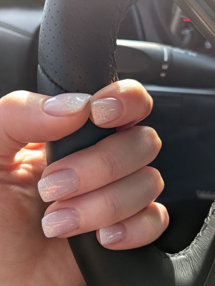 Elegant Nude Nail Design with Shimmering Glitter Accent for Versatile Sophistication.