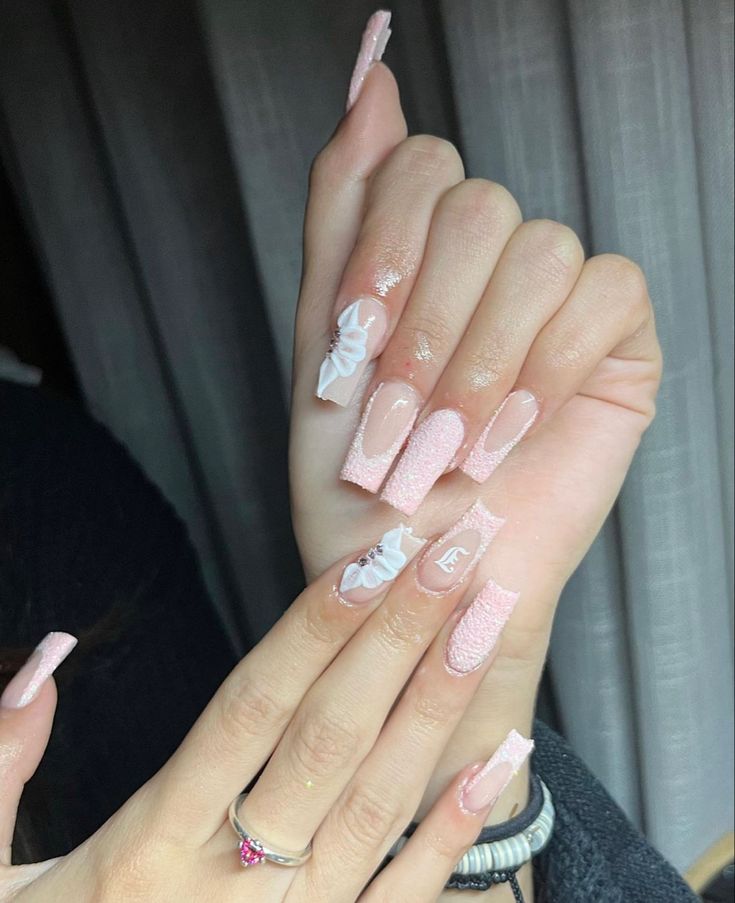 Chic Pink and White Nail Design with Matte, Glitter Finishes and Intricate Embellishments for Elegance.