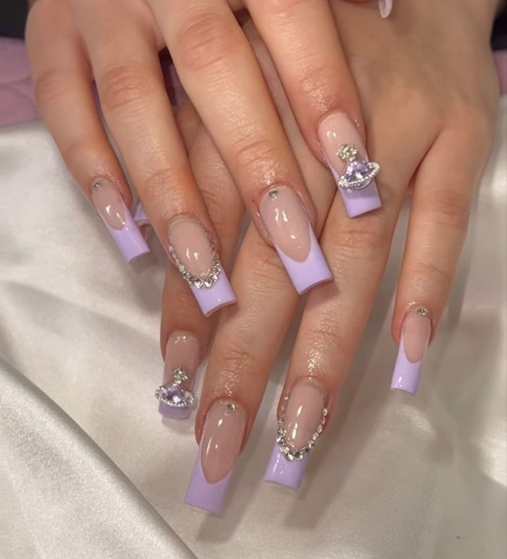 Sophisticated Lavender and Nude Nail Design with Rhinestones and Unique Embellishments.