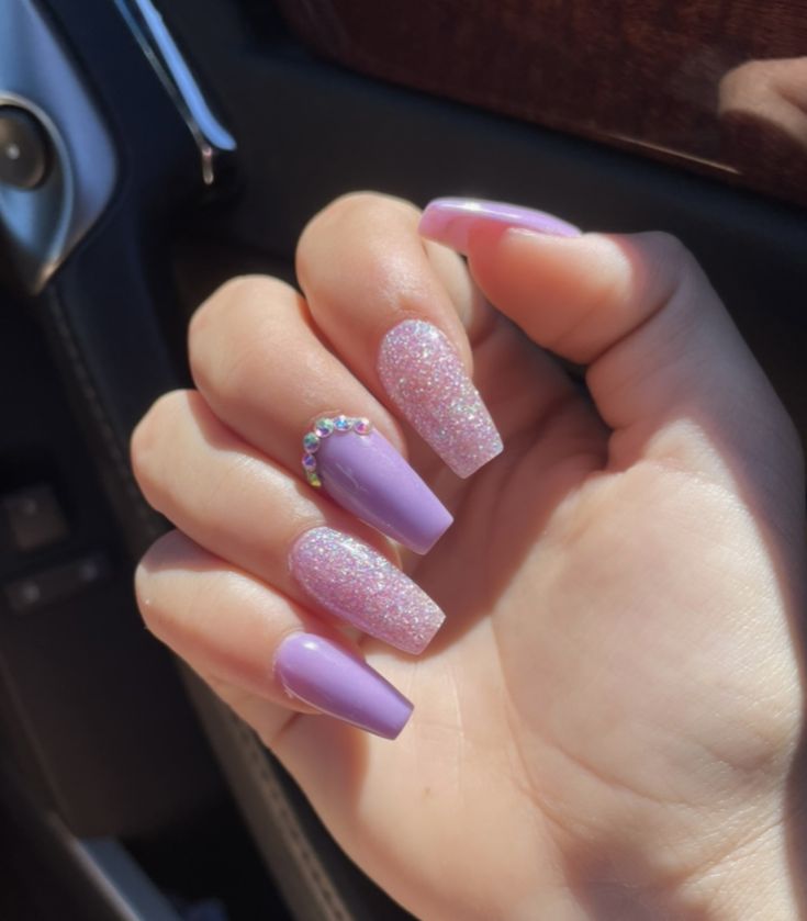 Vibrant Lavender Glitter Manicure with Playful Texture and Elegant Rhinestone Detail.