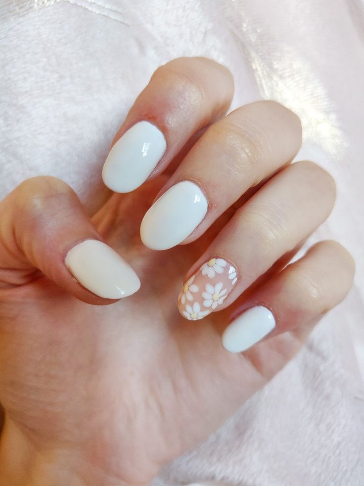 Elegant Chic Nail Design with Soft White Polish and Floral Accent for Versatile Occasions.