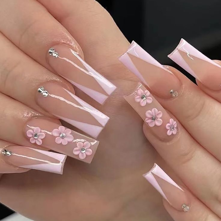 Elegant Long Square Nail Design with Soft Pink Base, White Stripes, Floral Accents, and Sparkling Rhinestones.