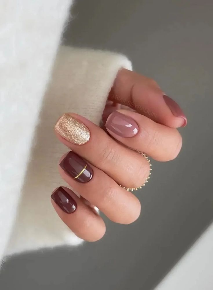 Chic Nail Design: Deep Burgundy, Soft Taupe, and Sparkling Gold with Subtle Gold Stripe