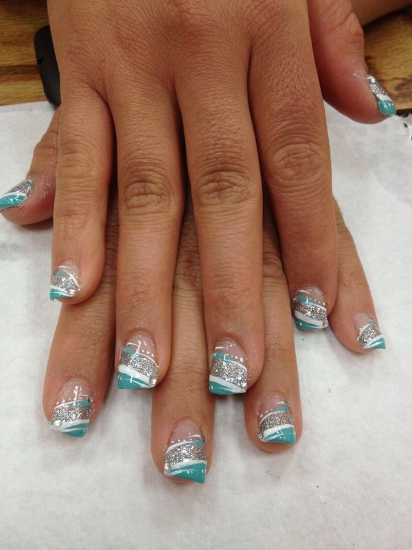 Chic Turquoise and Silver Nail Design with Geometric Patterns and Glitter Finishes.