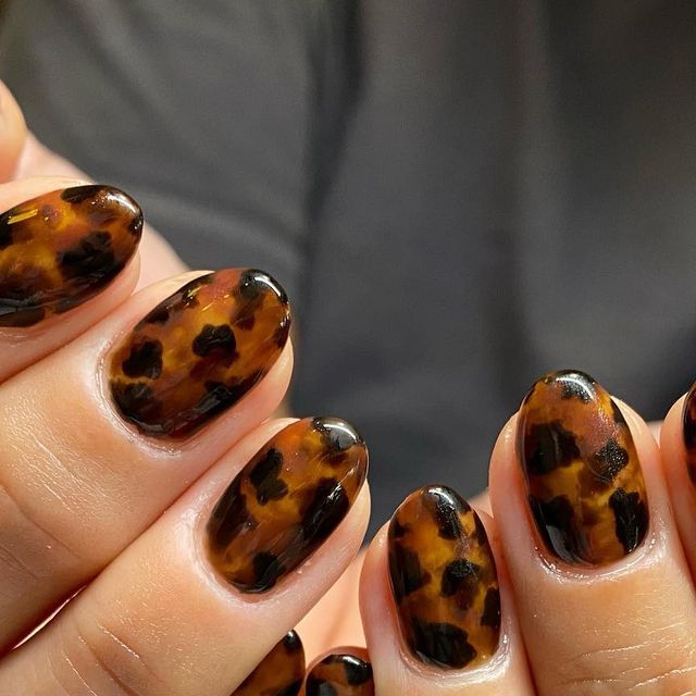 Chic Tortoiseshell Nail Design: Glossy Finish with Warm Brown and Black Hues