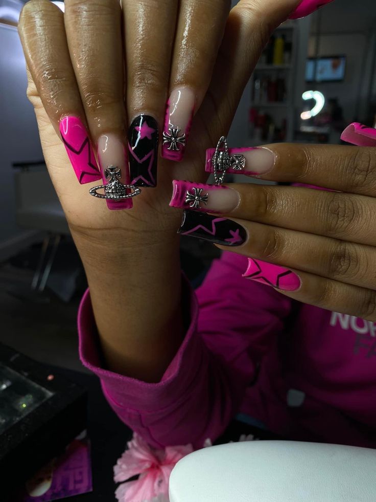 Vibrant Bold Pink and Black Nail Design with Star Motifs and Glamorous Embellishments.