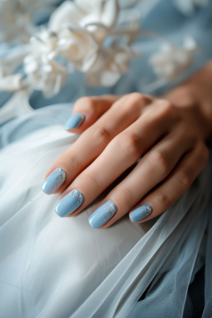 Chic Elegant Nail Design: Soft Blue Base with Shimmering Silver Accents for Special Occasions.