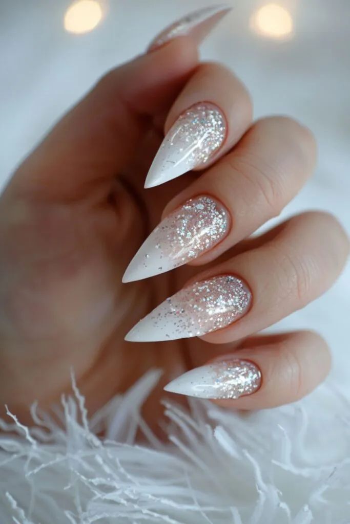 Elegant Gradient Nail Design with Pointed Shapes and Glitter Accents.