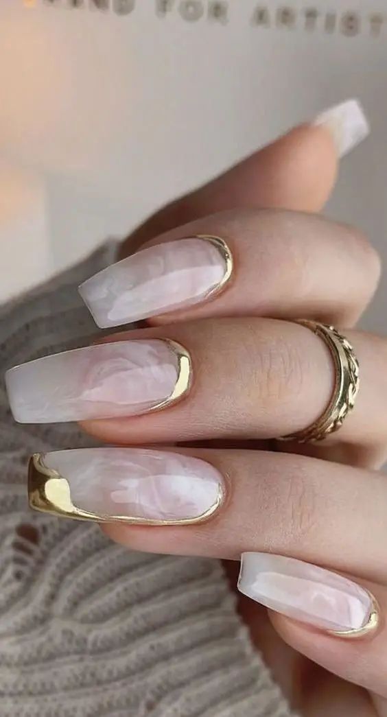 Sophisticated Translucent Pink Nails with Glamorous Gold Tips and Artistic Marbling.