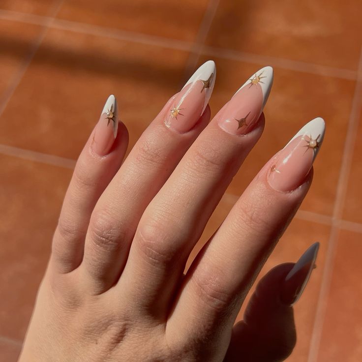Chic Almond-Shaped Nails: Glossy Nude with White Tips and Whimsical Gold Stars