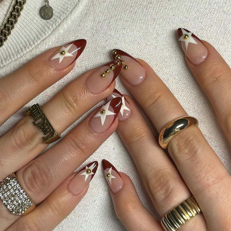 Chic Red-Tipped Nail Design with Star Patterns and Metallic Beads