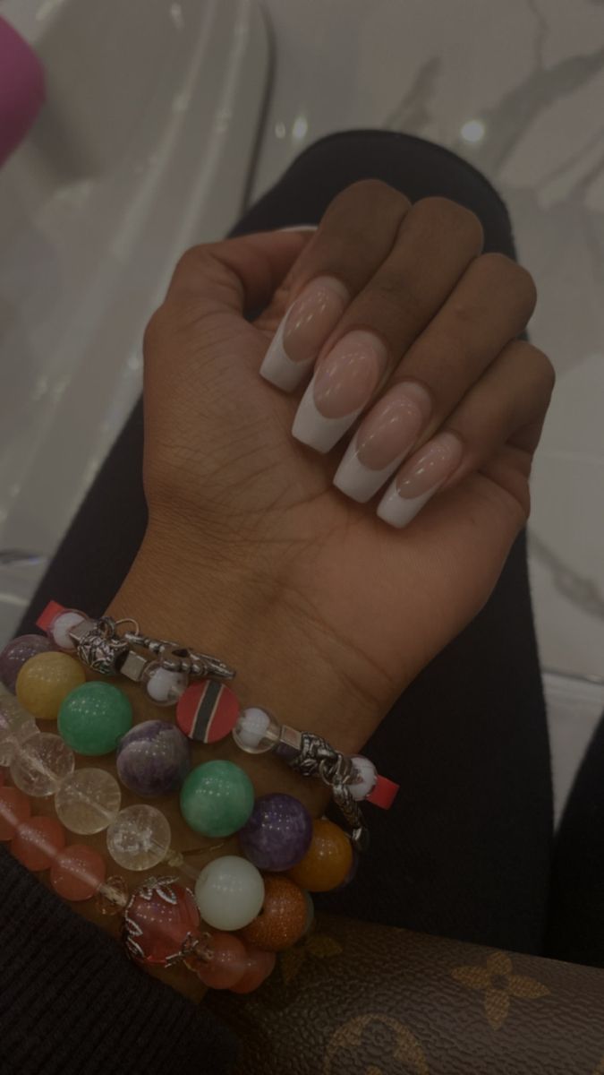 Chic Long Square Nails with Nude Base and Classic French Tips, Enhanced by Colorful Beaded Bracelets.